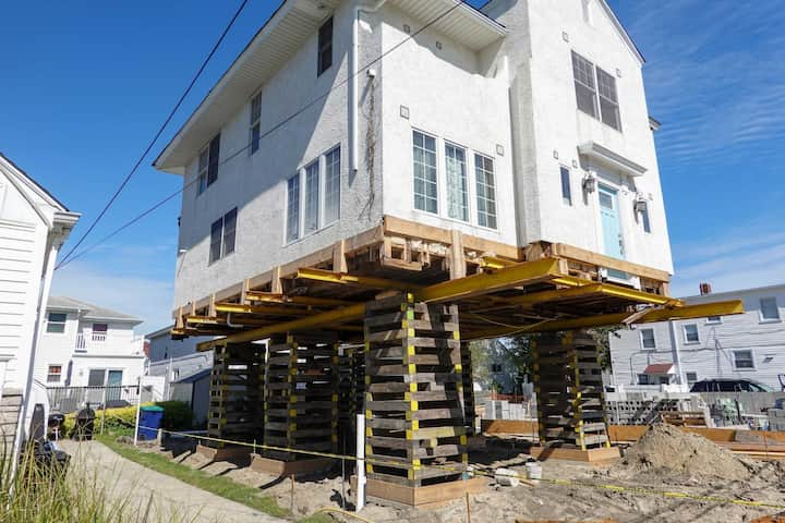 A team of professionals using specialized equipment to raise a house in Fayetteville, preparing it for elevation and renovation